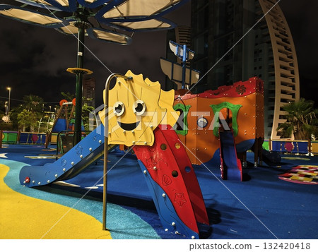 playground lit with city ambiance, urban park scene with illuminated playground and sunset shadows 132420418