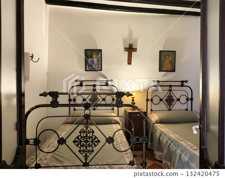 historic bedroom featuring twin beds and icons, decorative guest room with iron beds and devotional 132420475