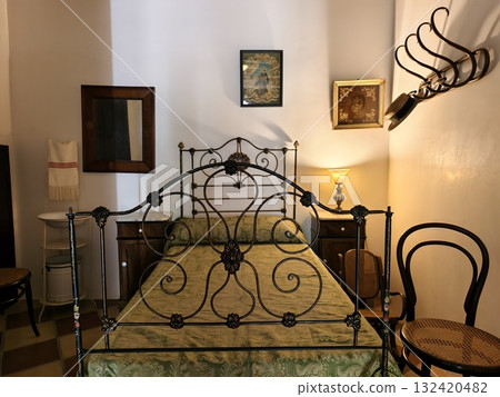 cozy bedroom ambiance, charming bedroom scene featuring ornate headboard and inviting textiles 132420482