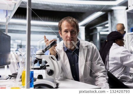 Scientist attends online video call in research lab to present discovery in chemistry and biotechnology. Teleconference with healthcare data, molecular biology and advanced research results. 132420793