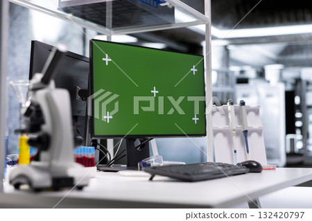 Green screen desktop pc on a desk in empty laboratory setting, testing tools and scientific instruments capture the environment of bioscience research. Medical discovery and diagnostics. 132420797