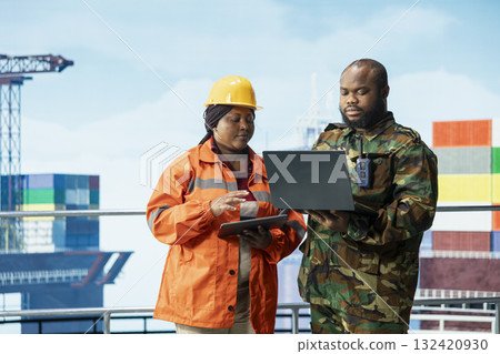 Soldier working with offshore installation manager to deter insurgent attacks. Military unit boarding drilling barge under maritime interdiction protocol, cooperating with technician 132420930