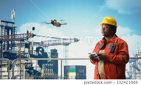 Woman on offshore platform deck doing site inspections using automated drone system. Drilling rig ship worker using aerial photography technology to determine optimal locations for pipelines, Woman on offshore platform deck doing site inspections using automated drone system. Drilling rig ship worker using aerial photography technology to determine optimal locations for pipelines, 132421008