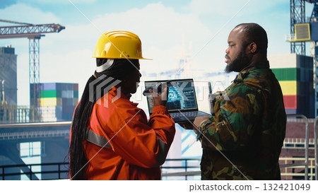 Military unit on offshore rig monitoring artificial intelligence defense systems with laptop. Soldier provides protection to drilling barge using AI machine learning surveillance systems, Military unit on offshore rig monitoring artificial intelligence defense systems with laptop. Soldier provides protection to drilling barge using AI machine learning surveillance systems, 132421049