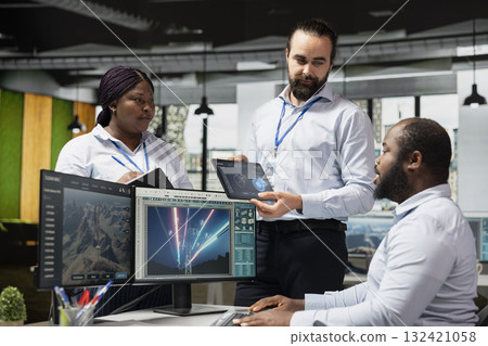 Team of sustainable energy tech company technicians monitoring eco power line towers. Teamworking colleagues use CAD software on PC to upgrade transmission tower systems, reducing carbon emissions Team of sustainable energy tech company technicians monitoring eco power line towers. Teamworking colleagues use CAD software on PC to upgrade transmission tower systems, reducing carbon emissions 132421058