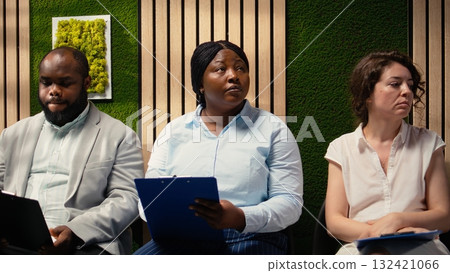 Black candidate filling in registration forms for job application and interview, ensuring a great recruitment process and successful meeting with the HR. Writes down qualifications. Camera A. Black candidate filling in registration forms for job application and interview, ensuring a great recruitment process and successful meeting with the HR. Writes down qualifications. Camera A. 132421066