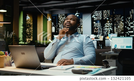 Business director reflects on a problem late at night after hours, methodical planning and creative contemplation to guide him toward a decision that balances rationality with positivity. 132421105