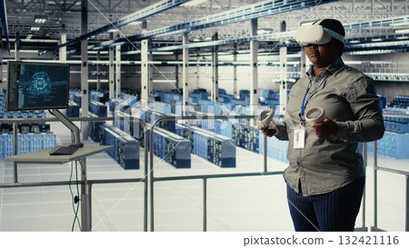 Data center IT expert investigates AI configurations using virtual reality, making adjustments for optimal function. Server hub engineer checks artificial intelligence error using VR headset, camera A 132421116