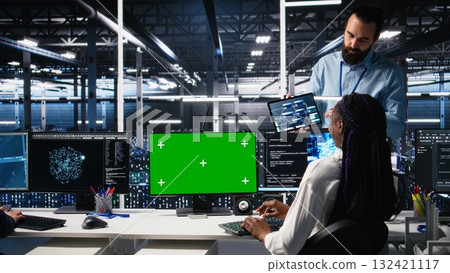 Female programmer talking with manager in data center, reviews AI diagnostics on green screen PC. IT expert and supervisor optimizes artificial intelligence systems using mockup computer, camera A Female programmer talking with manager in data center, reviews AI diagnostics on green screen PC. IT expert and supervisor optimizes artificial intelligence systems using mockup computer, camera A 132421117