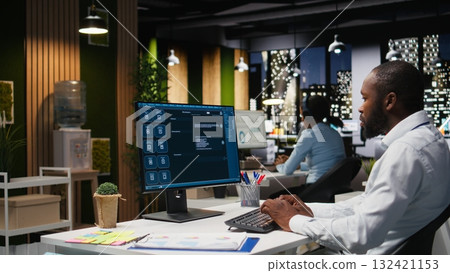 Black worker uses AI chatbot system at desktop for problem solving tasks, futuristic technology highlighting smart algorithms and machine learning. Communication and IT support. 132421153