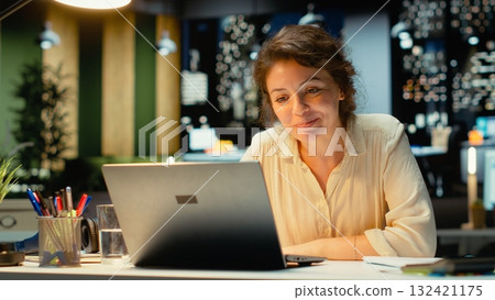 Surprised woman receiving a contract deal offer and feeling satisfied, working after hours for a career breakthrough. Business manager smiling in excitement for an amazing opportunity. Camera B. Surprised woman receiving a contract deal offer and feeling satisfied, working after hours for a career breakthrough. Business manager smiling in excitement for an amazing opportunity. Camera B. 132421175