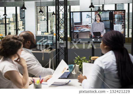 Diverse HR staff hosting a virtual meeting to interview a candidate via web video conference, discussing the job application and professional background of the person for a potential fit. 132421229