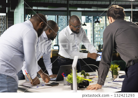 Colleagues and employees exchanging ideas during a business meeting. Professional team examines financial data, targets and business intel to align objectives for corporate progress. 132421293