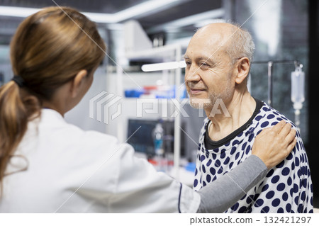 Woman specialist reassuring and bonding with senior patient in research lab, showing empathy for encouragement. Placing her hand on him for affection, safety and prevention study. 132421297