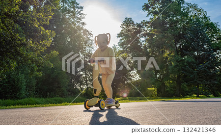 Little girl scooter. Toddler riding yellow scooter. Park road summer play. Little girl scooter. Toddler riding yellow scooter. Park road summer play. 132421346