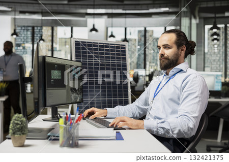 Technician working for green tech company uses CAD app to optimize sustainable solar panel fabrication with advanced assembly lines. Product designer innovates solar cell manufacturing processes 132421375