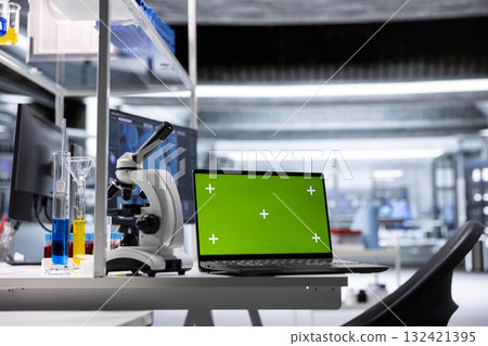 Isolated chroma key display on laptop in empty biolab setup with microscope and specimen tools. Workspace illustrates molecular biology research and biochemistry in healthcare science. 132421395