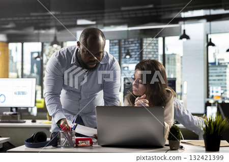 Professional business people analyze documents and graphs for risk assessment. Diverse work team collaborating on report writing, forecasting and performance metrics in modern office. Professional business people analyze documents and graphs for risk assessment. Diverse work team collaborating on report writing, forecasting and performance metrics in modern office. 132421399