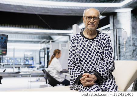 Portrait of old man starting a clinical trial in research lab to test new drug, sitting on a bed and waiting for a thorough examination. Senior person participates in health progress. 132421405
