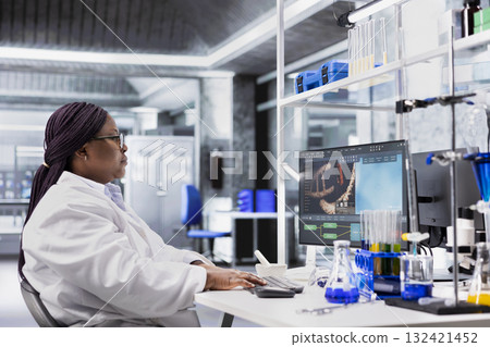 Black woman working in biotechnology lab surrounded by modern equipment. Conducting research study for genetics, nanotechnology and healthcare data, supporting pharmaceutical science. 132421452
