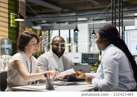 Human resources team conduct CV evaluation with candidate during job interview in a business space, analyzing work experience and qualifications for career development. Talent acquisition. 132421465