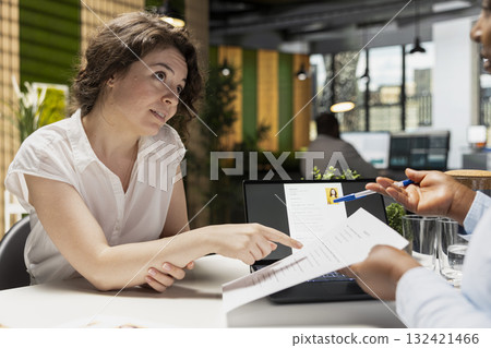 Candidate and HR manager going over job position benefits during formal meeting, discuss employment package as wellness programs, monthly salary, rights and annual compensation details. Candidate and HR manager going over job position benefits during formal meeting, discuss employment package as wellness programs, monthly salary, rights and annual compensation details. 132421466