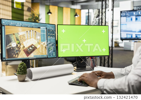 Male developer decorating apartment layout on 3D software next to green screen display, working with interior design tools for residential decorations project. Real estate management. 132421470