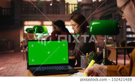 Focused senior man reading academic text with chroma key on pc at the university, sitting in vintage study area and browsing online coursework. Knowledge and ambition. 132421489
