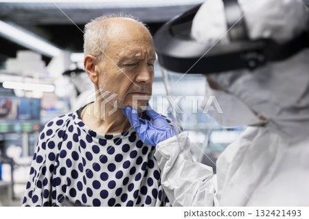 Doctor in biohazard lab conducts medical trial on a contagious patient, studying disease transmission, symptoms and antiviral drug effectiveness to develop treatments in virology. Doctor in biohazard lab conducts medical trial on a contagious patient, studying disease transmission, symptoms and antiviral drug effectiveness to develop treatments in virology. 132421493