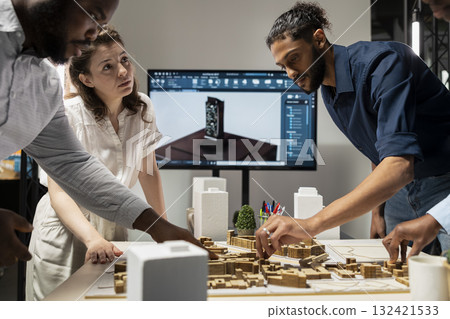 Diverse colleagues review structural plans for a property investment opportunity, balancing business objectives with innovation and sustainability in the real estate sector. City planning. Diverse colleagues review structural plans for a property investment opportunity, balancing business objectives with innovation and sustainability in the real estate sector. City planning. 132421533