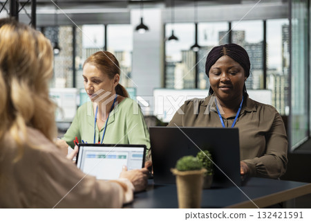 Diverse office colleagues reviewing business insights on laptop before setting goals in modern corporate briefing session. Analyzes financial updates in support of productivity and growth. 132421591