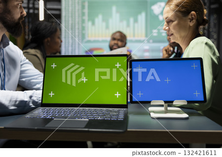 Diverse team in a dark office shares insights and exchanges feedback, finalizing company agenda during a collaborative project briefing with global stakeholders. After hours discussion. 132421611