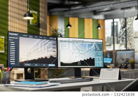 PC in empty engineering office used to upgrade transmission tower systems, improving sustainable energy integration. Computer in green tech company workplace used to design power lines infrastructure 132421636