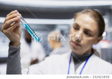 Female expert checking DNA chemical matter in test tubes for color change during laboratory testing procedure for new drug. Biotechnology innovation, clinical research and medicine progress. 132421659