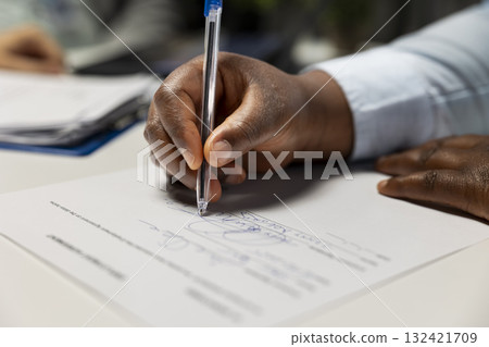 Close up of black candidate signing legal contract paper during HR meeting, beginning the hiring process and onboarding journey. Exciting multinational company job position. Career growth. Close up of black candidate signing legal contract paper during HR meeting, beginning the hiring process and onboarding journey. Exciting multinational company job position. Career growth. 132421709