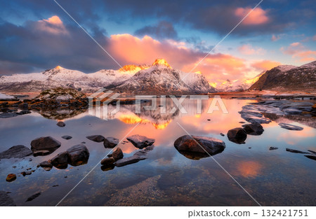 Landscape with snowy mountains reflecting on water with stones Landscape with snowy mountains reflecting on water with stones 132421751
