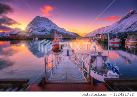 Fishing boats in harbor at sunset with snowy mountains at sunset Fishing boats in harbor at sunset with snowy mountains at sunset 132421758