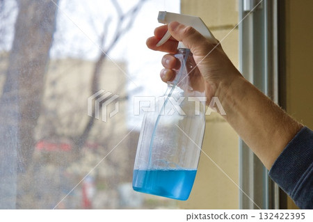 Hand holding window cleaning spray bottle Hand holding window cleaning spray bottle 132422395