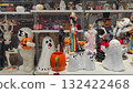 Colorful Halloween decorations including ghosts, pumpkins, and skeletons displayed on shelves in a festive retail environment 132422468