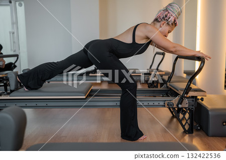 Pilates, reformer and women in class with machine for exercise, workout and improve posture. Fitness club, trainer and people with resistance equipment for wellness, health and balance for strength Pilates, reformer and women in class with machine for exercise, workout and improve posture. Fitness club, trainer and people with resistance equipment for wellness, health and balance for strength 132422536