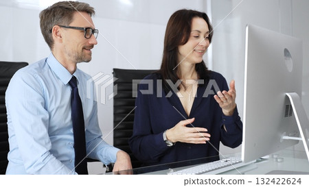 Businesspeople group collaborating and discussing strategies in modern office setting, smiling professionals analyzing data on computer during team meeting, successful partnership concept. Business Businesspeople group collaborating and discussing strategies in modern office setting, smiling professionals analyzing data on computer during team meeting, successful partnership concept. Business 132422624