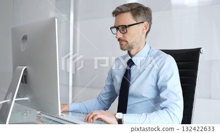 Mature businessman in office concentrating on important computer work, typing on keyboard, engaging in professional tasks, representing technology, development, and progress Mature businessman in office concentrating on important computer work, typing on keyboard, engaging in professional tasks, representing technology, development, and progress 132422633