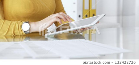 Woman working on digital tablet in office, accessing business documents and technology data. Audit and taxes in business 132422726