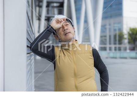 A man in work clothes with an air-conditioned vest suffering from heatstroke A man in work clothes with an air-conditioned vest suffering from heatstroke 132422944