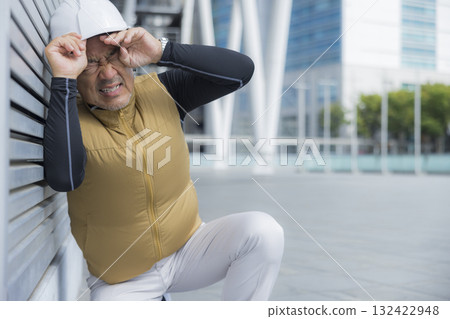 A man in work clothes with an air-conditioned vest suffering from heatstroke 132422948