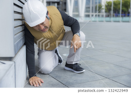 A man in work clothes with an air-conditioned vest suffering from heatstroke A man in work clothes with an air-conditioned vest suffering from heatstroke 132422949