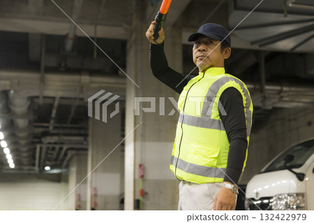 一名男子在地下停車場引導乘客 一名男子在地下停車場引導乘客 132422979