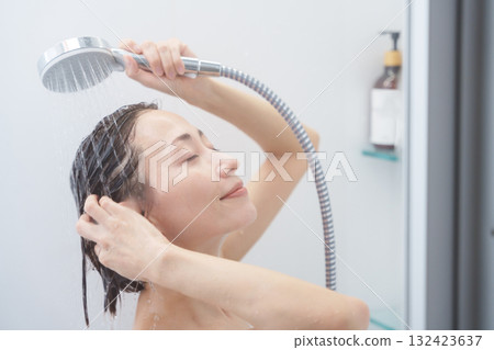 一名婦女在浴室(浴室、淋浴、沐浴)中洗頭 一名婦女在浴室(浴室、淋浴、沐浴)中洗頭 132423637