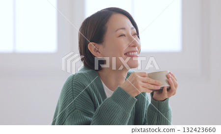 Middle-aged woman holding a mug Middle-aged woman holding a mug 132423660