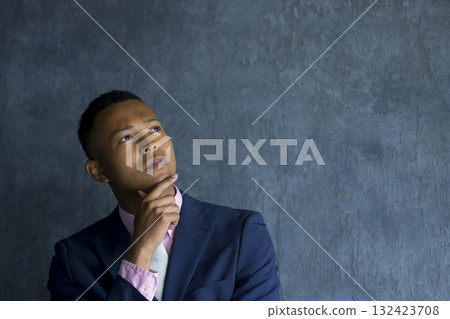 A foreign man wearing a suit and thinking 132423708